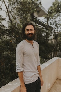 a man with a beard standing on a balcony