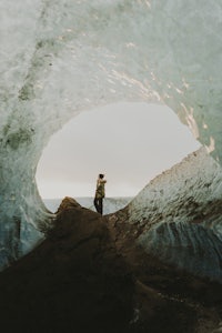 a person standing in the middle of an ice cave